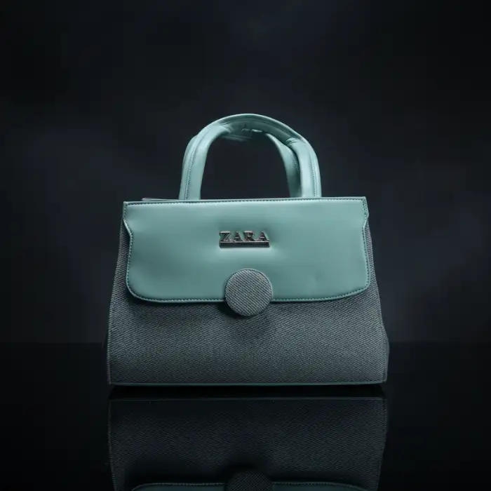 Zara mint green dual-texture handbag with top handles and silver logo on black reflective background